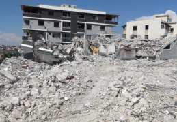 Ağır hasarlı binayı yıkan kepçe operatörü enkaz altında kaldı