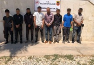 Polis yelekli, silahlı, telsizli ve kelepçeli göçmen kaçakçıları