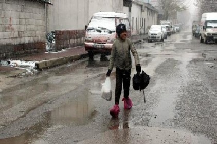 11 yaşındaki çocuk soğuk havada ayaklarında poşetle çalışıyor