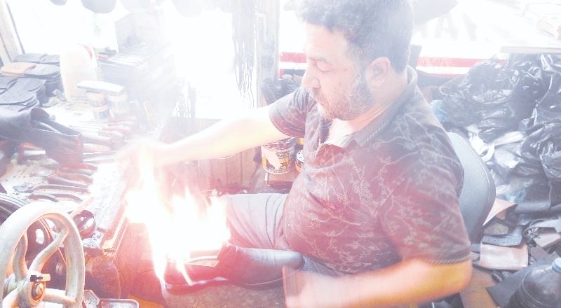 Ayakkabıları 45 derecede ateşle yakarak boyuyor