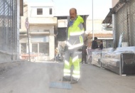 Döviz bozduranın evinin önünü temizliyor