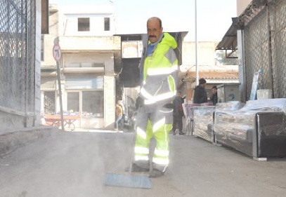 Döviz bozduranın evinin önünü temizliyor