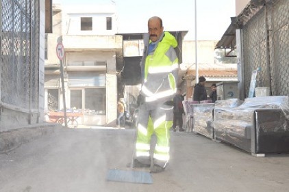 Döviz bozduranın evinin önünü temizliyor