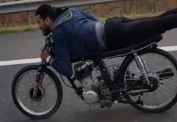 Motosikletin üzerinde boylu boyunca uzanarak yolculuk ettiler 