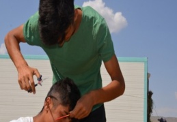 Tatile gelen üniversite öğrencisi yaylacıların tıraşlarını yapıyor 