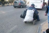 Tekerlekli sandalye ile kağıt topluyor